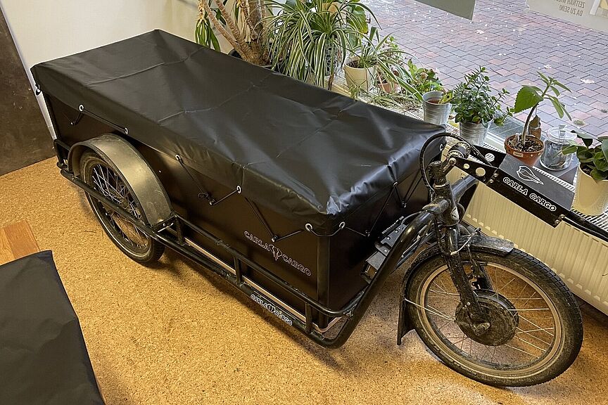 Carla Cargo mit Kiste und Plane.