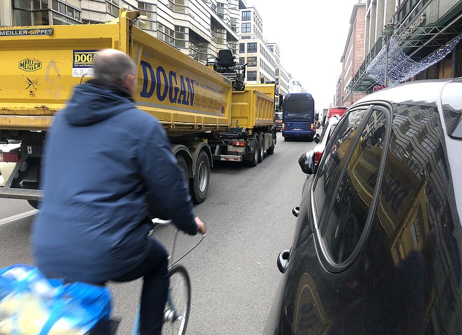 Enge im Straßenverkehr ohne separaten Radweg Man fährtzwischen LKW und parkenden Autos Rad
