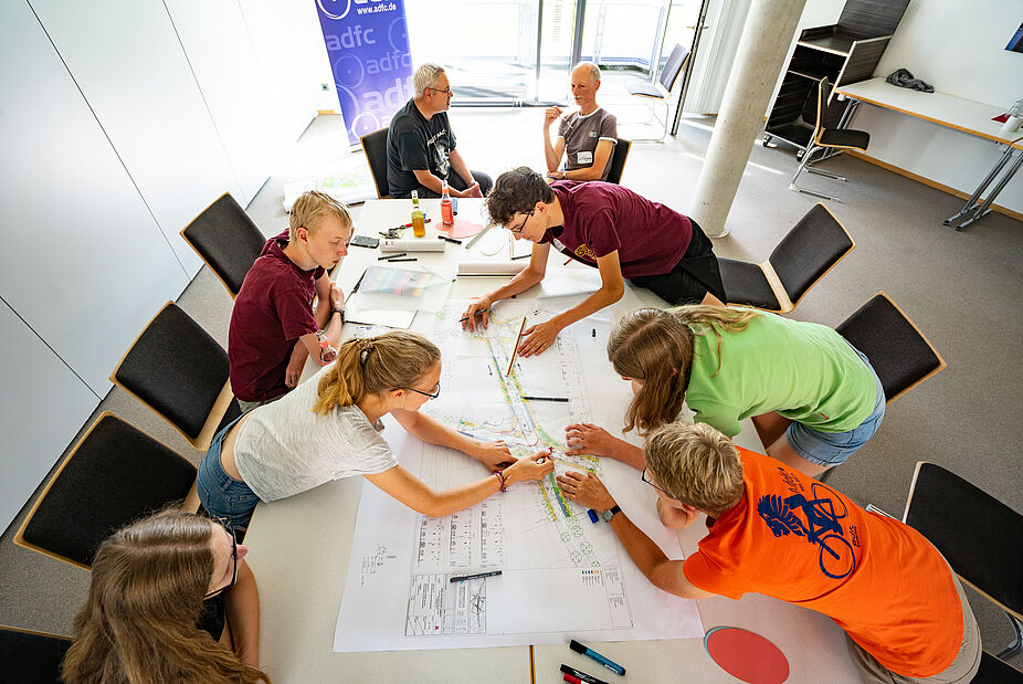 Zusammenarbeit beim ADFC Gruppe sitzt um Tisch mit Unerlagen