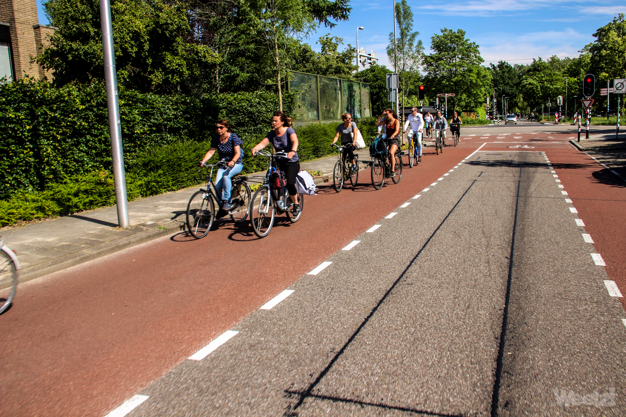 Breite, eingefärbte Radfahrstreifen auf beiden Seiten sind für Radfahrende. Autos nutzen den Mittelstreifen, wenn sie Radfahrende überholen., 